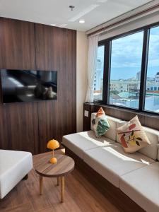 a living room with a couch and a large window at BRIO Urbano Apartment in Da Nang