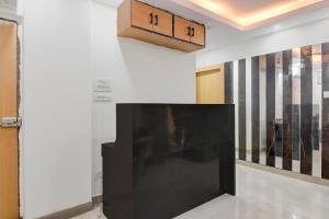 a large black tv on a wall in a room at Hotel Royal Place in Kolkata
