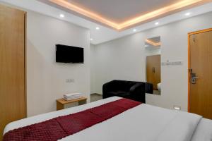 a bedroom with a bed and a tv on the wall at Hotel Royal Place in Kolkata