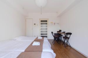 a bedroom with a bed and a table with chairs at Minami-Ohashi Good Place House in Fukuoka