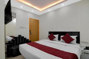 a bedroom with a large white bed with red pillows at Hotel Royal Place in Kolkata