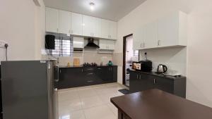 a kitchen with white cabinets and a stainless steel refrigerator at SSN Home Stays in Bangalore near PLAY Arena in Bengaluru