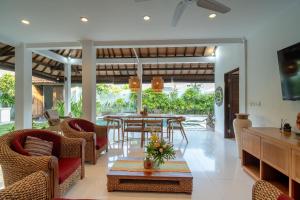 uma sala de estar com mesa e cadeiras em Sari Temuku Villa em Seminyak