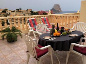 a table with fruits and bottles of wine on a balcony at Cala la Manzanera in Calpe