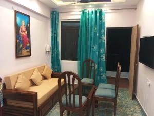 a living room with a couch and two chairs at Plams Beach comfort in Benaulim