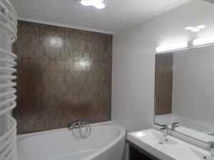 a bathroom with a tub and a sink at Hotel Írisz in Nyíregyháza
