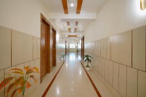 a hallway with potted plants in a building at Hotel Saubhagya in Ahmedabad