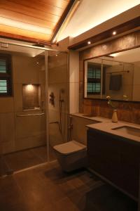 a bathroom with a shower and a toilet and a sink at Aelam Acres in Chillithodu