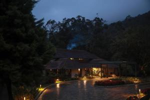 a house in the middle of a garden at night at Aelam Acres in Chillithodu