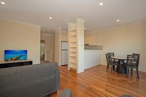 un salon avec un canapé et une table dans l'établissement Lofberg Villas, à Muswellbrook 5 autres photos