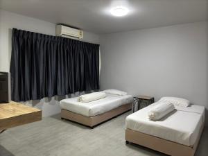 彭世洛里台宾馆的一间设有两张床和电视的房间