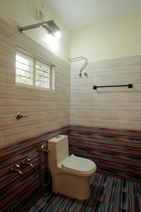 Un baño con inodoro y ducha en Tapovana - Hillside Retreat, en Thekkady