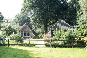 a house with a fence in front of a yard at Gastenverblijf Het Muzehuis in Dalfsen