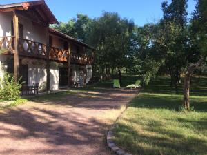 a building with a pathway leading to a yard at La Ferme aux Biches in Commelle-Vernay