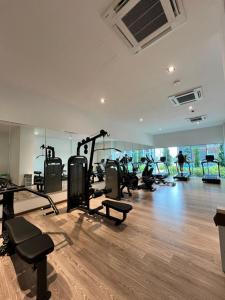 a gym with tread machines and people exercising in the gym at Little Haven - Cozy 2BR with Big Swimming Pool in Kajang