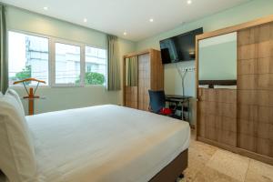 a bedroom with a large bed and a flat screen tv at Mirah Villas in Denpasar