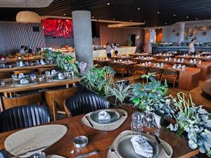 a restaurant with wooden tables and chairs and plants at Luxurious Apartments at Grand Sapphire Resort & Casino in Bahçeler +46 photos