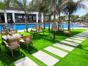 a patio with tables and chairs next to a pool at Luxurious Apartments at Grand Sapphire Resort & Casino in Bahçeler