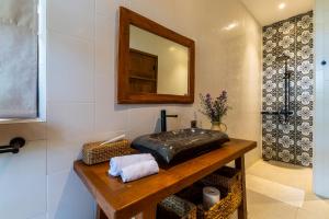 a bathroom with a sink and a mirror at Casa Doreena Villa by Betterplace in Munggu +87 photos