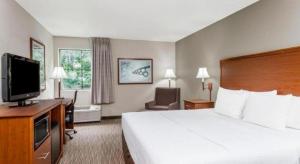 a hotel room with a bed and a flat screen tv at Days Inn Springfield South in Springfield
