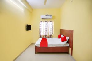 Un dormitorio con una cama con almohadas rojas y una ventana. en Hotel O Sai Saugat, en Bilāspur