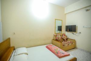 a bedroom with a bed and a mirror and a chair at Hotel White House International in Dhaka