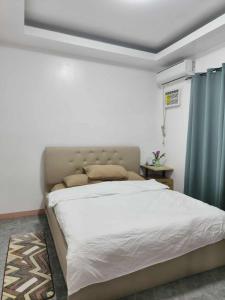a bedroom with a large bed with a blue curtain at Kimz Residences in San Antonio