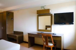 a room with a desk with a tv and a mirror at Country Village Hotel in Cagayan de Oro