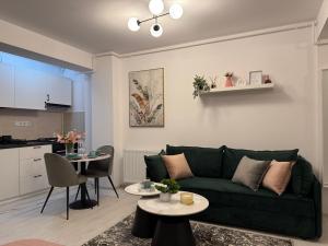 un salon avec un canapé vert et une table dans l'établissement Sofia Residence - Otopeni Airport & Therme I Libertatii Gardens - free pool facilities, à Otopeni