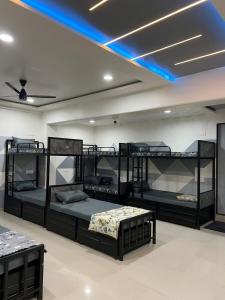 a room with four bunk beds and a blue light at Royal Dormitory in Jālgaon