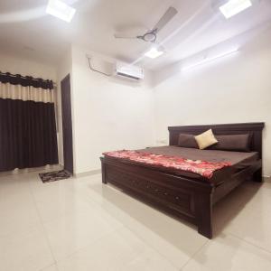 a bedroom with a bed in a white room at Awesome 3bhk apartment in Hyderabad