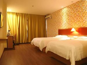 a hotel room with two beds and a brick wall at 7 Days Inn Zhenjiang Jiangsu University in Zhenjiang