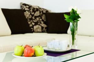 a table with two plates of apples and a vase with roses at VOX Design Hotel in Vienna