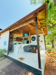 Una zona de estar al aire libre de una casa con techo. en Bale Penida Villa, en Nusa Penida