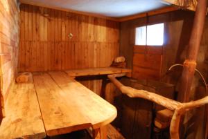 Cabaña de madera con mesa de madera y ventana en Slavyansky Dom Guest House, en Alakhadzi