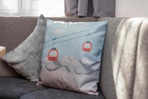 a pillow on a couch with a picture of a cable car at Sonnwendhof in Ischgl +51 photos