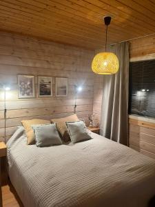 ein Schlafzimmer mit einem großen Bett und einem Kronleuchter in der Unterkunft Ruka Snow&Sun 3 - 2 ski tickets included in Kuusamo