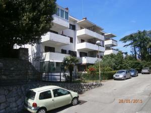 a white car parked in front of a building at Apartman Lovran in Lovran