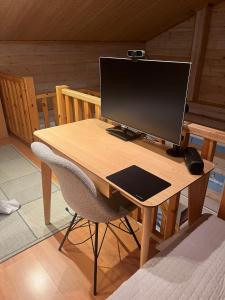 ein Computermonitor auf einem Schreibtisch mit einem Stuhl in der Unterkunft Ruka Snow&Sun 3 - 2 ski tickets included in Kuusamo