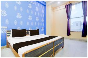 a bed in a room with a blue wall at Hotel Vihang Residency Near Vishwanath Temple in Rāmnagar