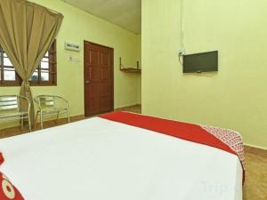 Un dormitorio con una cama grande y un televisor de pantalla plana. en Hotel O Saril Riverside HomestayNearLapangan Musara Alun, en Rawe