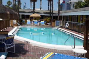 
a swimming pool with a pool table and chairs at Barefoot Bay Resort Motel in Clearwater Beach
