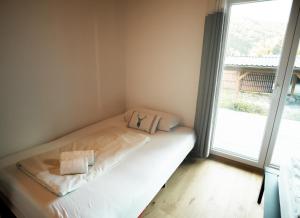 a bed in a room with a large window at S´Holzhäusle in Glanz