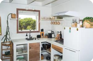 a kitchen with a refrigerator and a sink at The Perch Northland in Waihopo