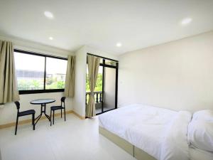 a bedroom with a bed and a table and chairs at Townhouse, 500m the Pink Line MRT, Near Airport 