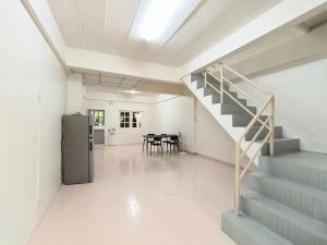 a room with a staircase and a table and chairs at Townhouse, 500m the Pink Line MRT, Near Airport 