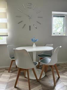 a dining room table with chairs and a clock on the wall at Highfield 2 rooms Apartment in Augsburg