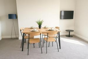 a wooden table and chairs in a room at Bright 2-Bed Top Floor Flat, Full Kitchen, Parking in Taunton +4 photos