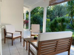 a porch with two chairs and a table at La Terrasse des Maldives in Saint-Paul