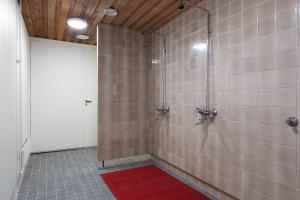 bagno con doccia e tappeto rosso di Kotimaailma Rooms - Ankkuri 1hh a Kotka